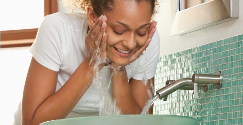 Woman washing face in sink